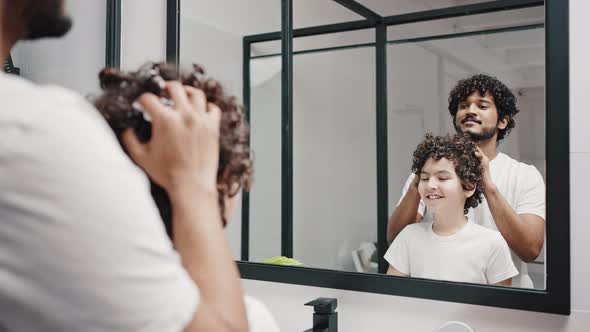 Asian Indian Man Takes Care of Curly Hair of Younger Brother