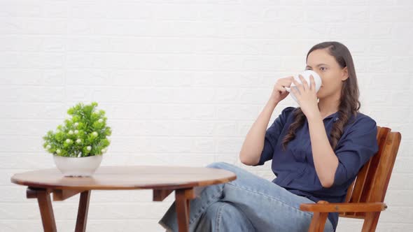 Indian girl enjoying coffee at a cafe bar