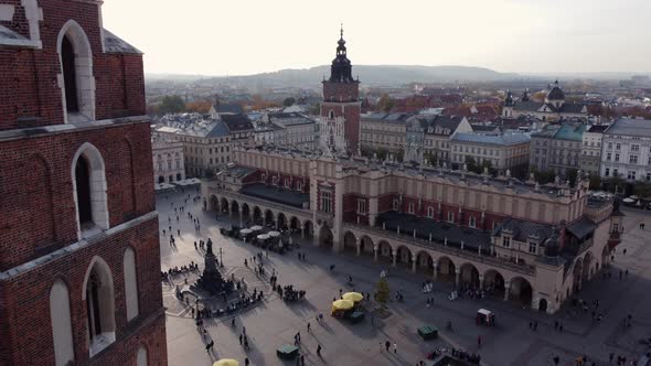 Aerial flying backwards from Renaissance Cloth Hall revealing St. Mary's church, Krakow