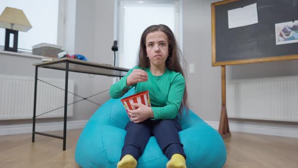 Curios Absorbed Little Person Eating Popcorn Watching TV Sitting on Soft Comfortable Bag Chair