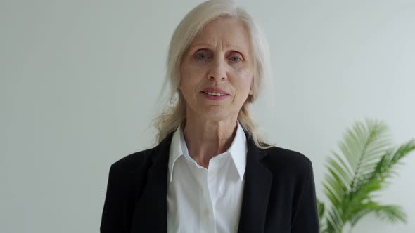 Portrait of a Beautiful Elderly Woman Who Smiles and Looks at the Camera