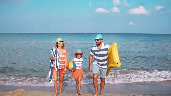 Father, Mother and Child against Blue Sea and Sky Background