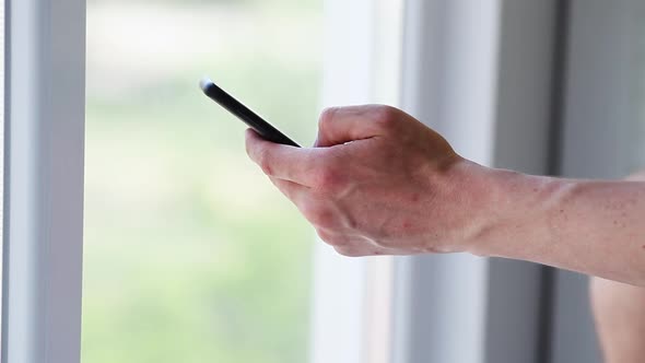 Side view. Hand of men using smartphone . Close-up of young man hand