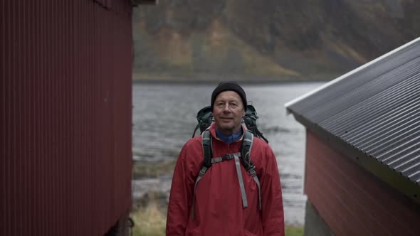 Hiker Standing Between Fisherman's Huts