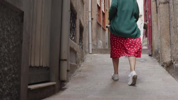 Woman Is Running in Old Narrow Street Looking Back On Camera and Smiling