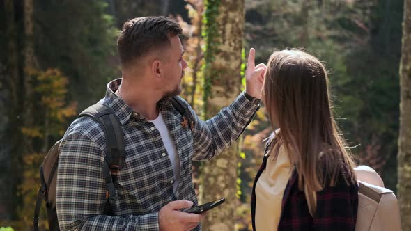 Pair of Travelers in Forest Hiking Looking Around