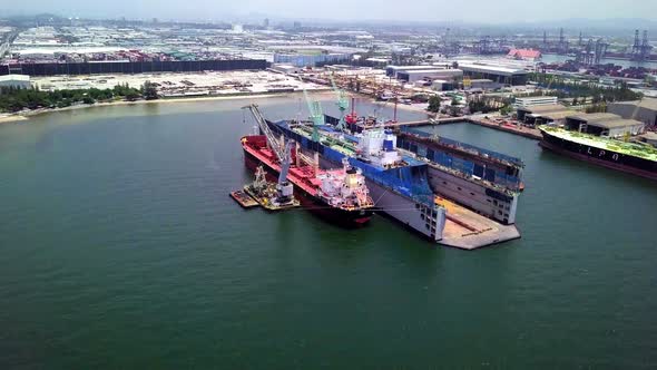 Aerial view of logistics concept a cargo ship being retrofit, repair and services on a floating dry