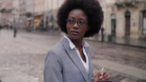 Afro American Business Lady Writing on Clipboard Outdoors