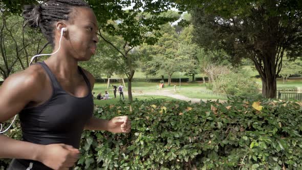 Attractive black african woman running in the park-slow motion