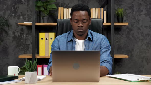 African American Businessman Works for Laptop Typing on the Keyboard in Office