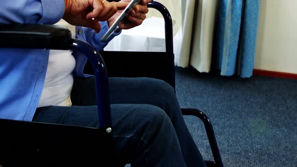 Retired person in wheel chair using tablet computer