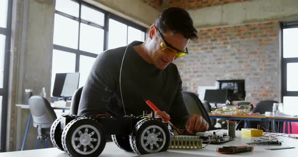 Male electrical engineer soldering a circuit board