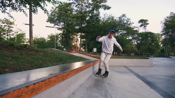 Aggressive Inline Roller Skater Doing Tricks in Concrete Skatepark Outdoors Slow Motion