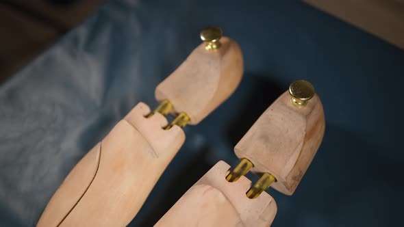 Two Used Shoe Trees Displayed on Blue Leather at Cobbler Workshop or at Home
