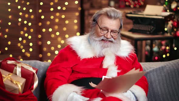 Male Santa Claus Smiling Read Wish List with Surprised Face Expression