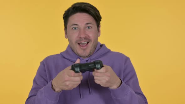 Man Playing Video Game Yellow Background