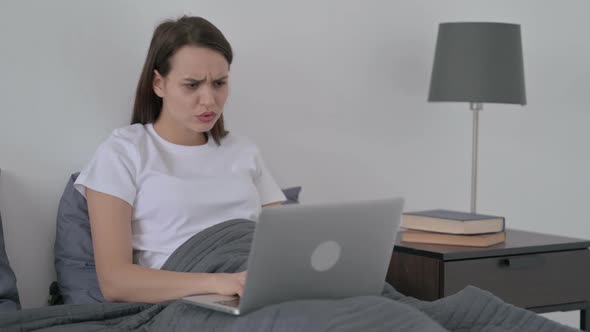 Woman Reacting to Loss on Laptop in Bed