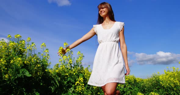 Beautiful woman walking in mustard field