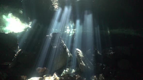 Sharp sun rays shining through water surface in Cenote Chikan Ha Yucatan Mexiko cave system