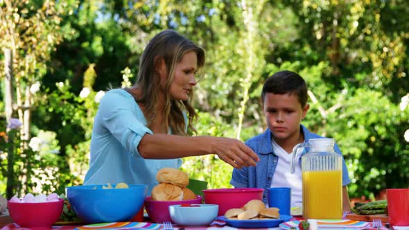 Mother interacting with her son while having meal