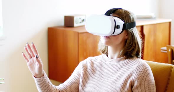 Woman using virtual reality headset in living room
