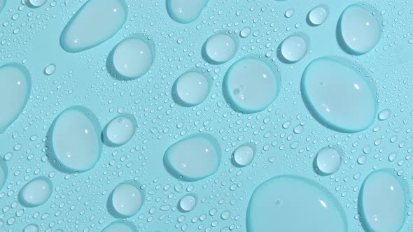 Macro Shot of Cosmetic Moisturizing Drops of Liquid on a Greenblue Pastel Background