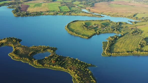 Blue Water Of Lake River And Green Countryside Landscape With Growing Greenery Forest