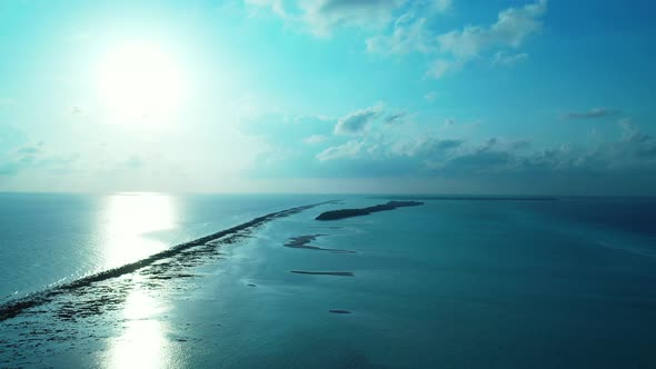 Wide angle drone abstract shot of a sunshine white sandy paradise beach and blue water background in