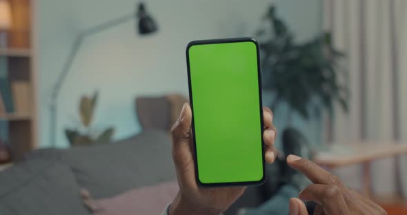 Close Up of African American Man Scrolling on Green Screen of Mobile