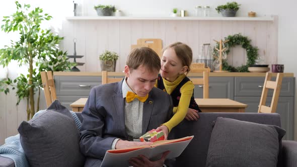 Little Girl Giving a Gift Box to Father at Home