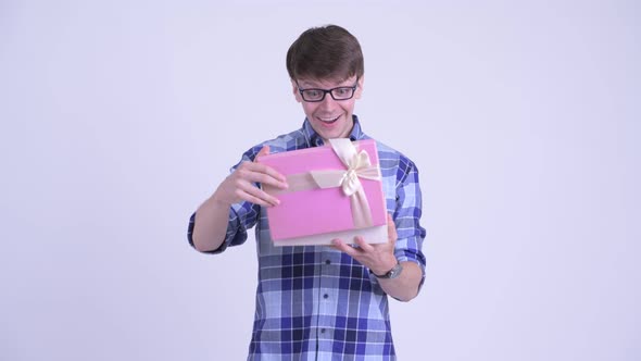 Happy Young Hipster Man Opening Gift Box and Looking Surprised