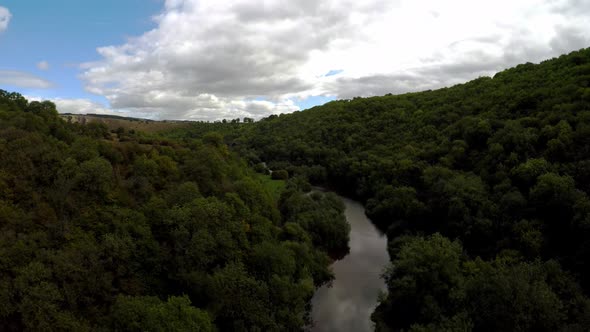 Aerial view of a river flowing through a peak district forest, commonly used by cyclists, hikers, po