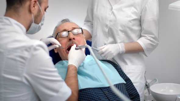 Mature Man Surrounded By Medical Staff at Dentistry