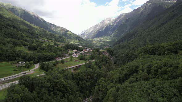 Beautiful alpine panorama with a small village next to the mountain pass road.