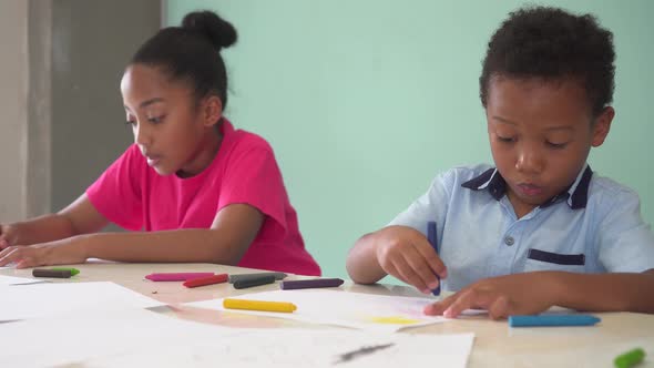African American Kids Learning How to Draw with Crayon on Table