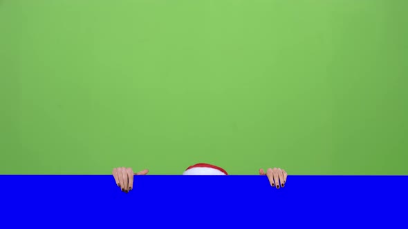 Santa Woman Looks Out of the Blue Board and Shows a Thumbs Up. Green Screen