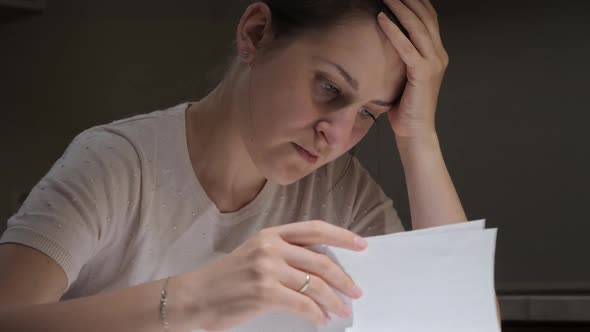 Portrait of Stessed Woman Feeling Frustrated While Reading Documents of Divorce