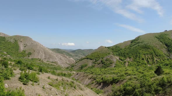 Daytime Mountain Landscape From Hills Covered with Greenery and a Small Village Below the Gorge