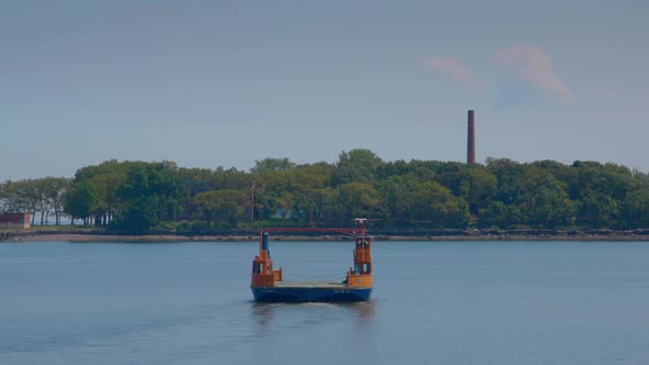 Roll-on, roll-off orange ferry heading to Hart Island, chimney in the background. Blue sky on a sunn