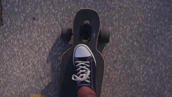 Riding Longboard Closeup Male Feet in Sneakers