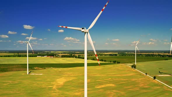 White wind turbines in sunny summer day, aerial view