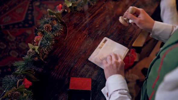 Envelopes for children at Christmas. Elf putting seal on the envelope quickly.