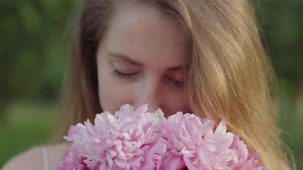 Extreme Close-up Face of Beautiful Woman Smelling Flowers. Portrait of Charming Caucasian Girl