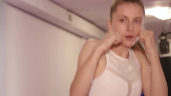 Active Girl Boxer Practicing Punches Fighting with the Shadow