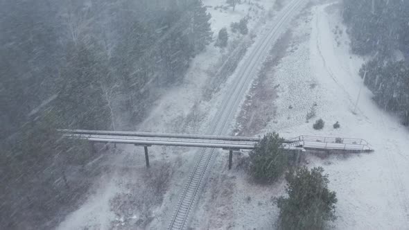 AERIAL: Rotating Shot of Overpass Bridge with Railway on a Snowstorm