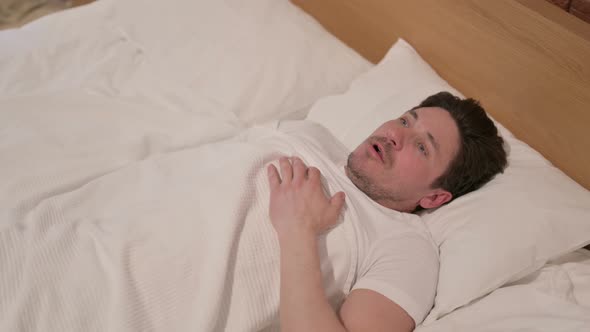 Middle Aged Man Waking up from Nightmare in Bed