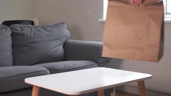 Millennial Woman at Home Bring Take Aways Food Package on Table. Delivery in Eco Friendly Bag