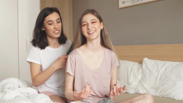 Two Gorgeous Romantic Girls Hugging While Sitting on the Bed.