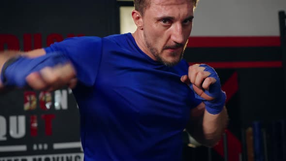 4K Caucasian man do sport training boxing exercise with punching the air at gym.