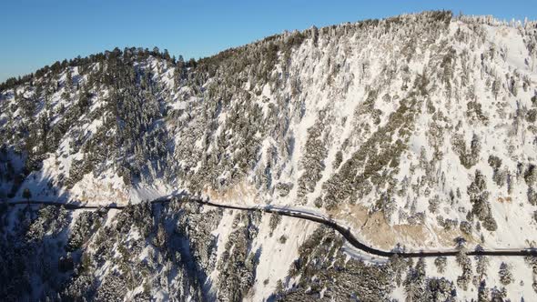 Aerial of a road through the mountains after a snow